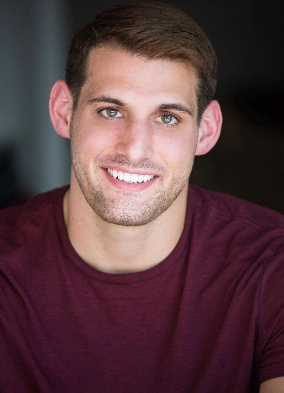 Devin Teer smiling in a burgundy shirt
